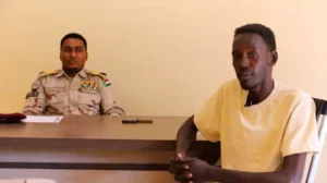 صورة مجتزأة من فيديو بتثته مليشيا الدعم السريع يظهر الصحفي معمر إبراهيم أثناء التحقيق معه بواسطة الناطق الرسمي باسم المليشيا الفاتح قرشي